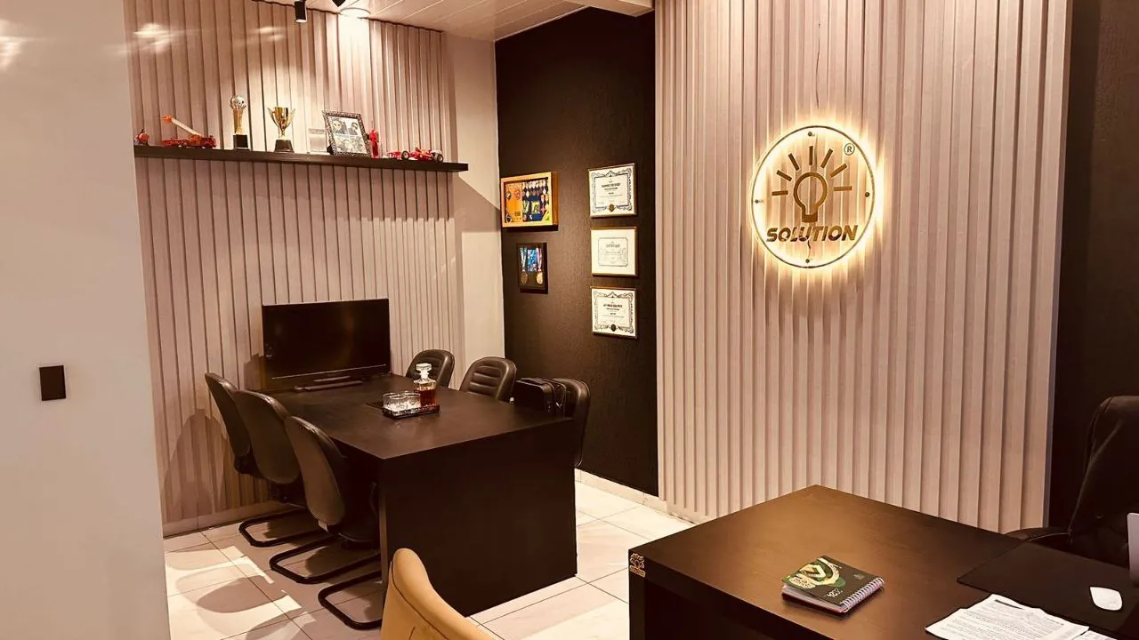 Sala de atendimento com o logotipo da Solution iluminado na parede
